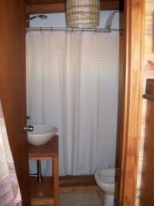 a bathroom with a white shower curtain and a toilet at El Ahora in El Eden