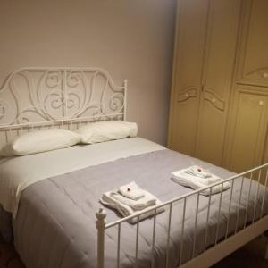 a bedroom with a white bed with towels on it at B&B Porta Girone in Civitanova Alta