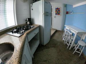 uma cozinha com um frigorífico branco e um lavatório em Recanto do Lago Buzios em Búzios