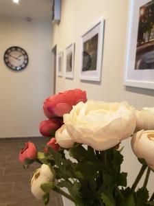 a vase with red and white flowers in a room at Mediterrán Villa Kecskemét in Kecskemét