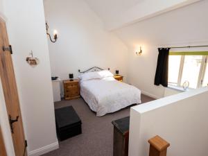 een slaapkamer met een bed en een raam bij Bodafon Hall Cottages in Llandudno