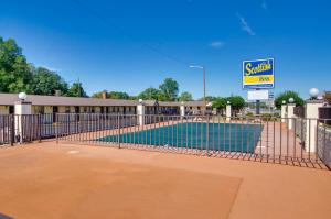 a swimming pool with a fence and a sign at Scottish Inns Collinsville - Martinsville in Collinsville