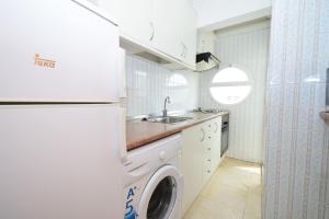 a kitchen with a washing machine and a sink at Los Caballos - Fincas Arena in Benidorm