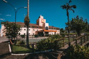 ein Gebäude mit einem Uhrturm und einer Palme in der Unterkunft Hotel 10 Joinville in Joinville