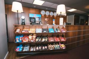 una tienda con un estante de comida y relojes en la pared en Hotel 10 Joinville, en Joinville