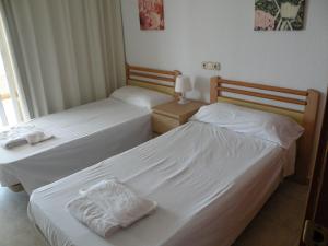 2 aparte bedden in een hotelkamer met rokken bij Torre Levante - Fincas Arena in Benidorm