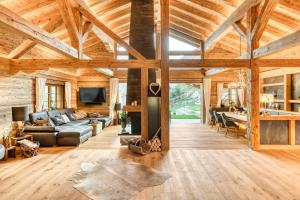 uma sala de estar com tectos em madeira e uma lareira em Chalet GM - Gesamtes Haus by A-Appartments em Brand