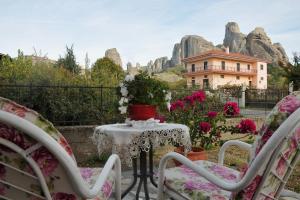 a table and chairs with a house in the background at Room Ntina Kastraki in Kastraki