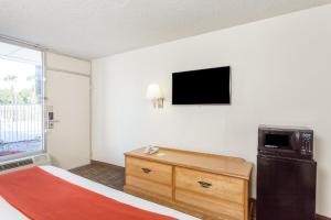 una camera d'albergo con letto e televisore a parete di Days Inn by Wyndham Adel I-75 ad Adel