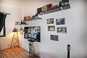 a living room with a tv on a wall with pictures at Top Center Relax, NDK & Vitosha str, FREE Secured parking in Sofia
