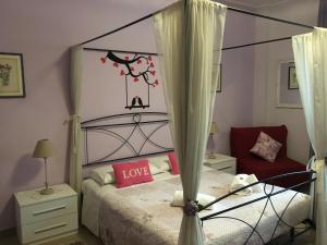 a bedroom with a canopy bed with love painted on the wall at La Giara Rooms in Verona
