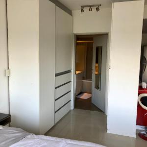 1 dormitorio con paredes blancas, 1 cama y pasillo en Hermoso loft vista panorámica en Buenos Aires