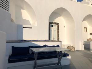 a living room with a table and a couch at Altana Cliffside Villas in Imerovigli