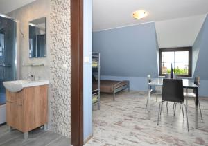 bagno con lavandino e tavolo con sedie di Pod Strzechą a Darłowo