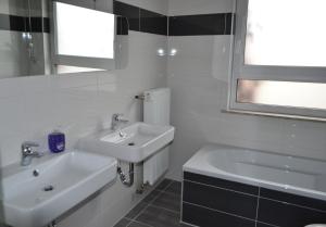 La salle de bains blanche est pourvue d'un lavabo et d'une baignoire. dans l'établissement Ferienwohnung Krone, à Sankt Johann