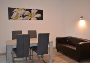 a dining room with a table and chairs and a couch at Ferienwohnung Krone in Sankt Johann