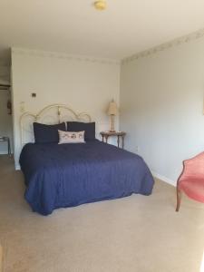 Schlafzimmer mit einem großen Bett mit blauer Tagesdecke in der Unterkunft Hawk Mountain Bed & Breakfast in Kempton