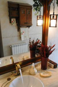 uma casa de banho com um lavatório e um espelho em Casa Monica em Narrillos de San Leonardo