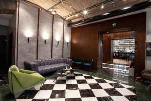 a lobby with a couch and a checkered floor at Hotel Solun in Trieste