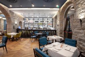 a restaurant with tables and chairs and a bar at Hotel Solun in Trieste