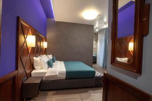 a bedroom with a bed with a purple ceiling at Hotel Solun in Trieste