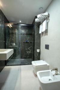 a bathroom with a shower and a toilet and a sink at Hotel Solun in Trieste