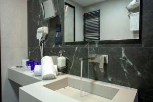 a bathroom with a sink and a mirror at Hotel Solun in Trieste