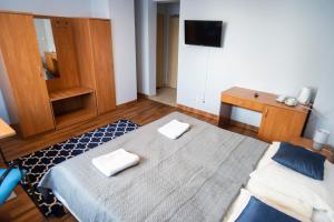 a bedroom with a bed with two towels on it at Hostel Mały Żagiel in Gdynia