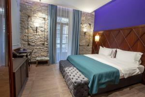 a hotel room with a bed and a stone wall at Hotel Solun in Trieste