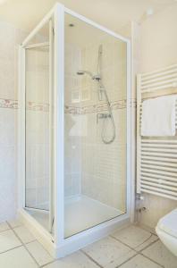 a shower with a glass door in a bathroom at The Neuadd Cottages in Crickhowell