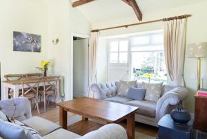 a living room with a couch and a table at The Neuadd Cottages in Crickhowell