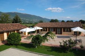 a house with umbrellas in the yard at Il Podere del Falco in Assisi