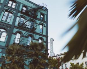 ein blaues Gebäude mit Palmen davor in der Unterkunft The Society Hotel in Portland