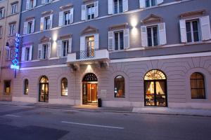 um grande edifício branco com muitas janelas em Hotel Solun em Trieste