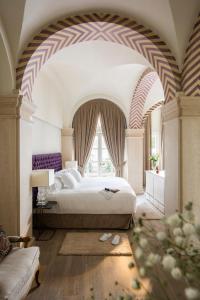a bedroom with a bed and a large window at Casa de Triana Luxury Suites by Casa del Poeta in Seville