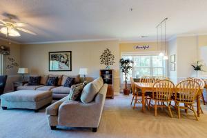 Myrtlewood في ميرتل بيتش: غرفة معيشة مع أريكة وطاولة وكراسي