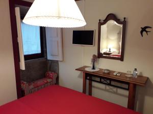 a bedroom with a red bed and a mirror at Casa do Progo in Ponte de Lima