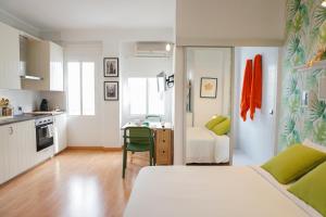 a bedroom with a bed and a kitchen with a table at Alemania & SOHO by ELE Apartments in Málaga