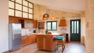 a kitchen with wooden cabinets and a stainless steel refrigerator at Villa Mathea in Kounoupidhianá