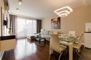 ein Wohnzimmer mit einem Tisch und einem Sofa in der Unterkunft Old Town Luxury Apartment in Krakau