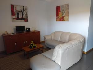uma sala de estar com um sofá branco e uma mesa em Sweet Dreams AL em Ponta Delgada