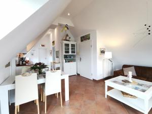Una cocina y una sala de estar con mesa y sillas. en Ferienwohnung Weitblick, en Prerow