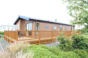 Casa de madera pequeña con terraza grande en Cosy Dreams Lodge, en Beal