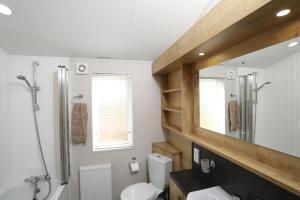 uma casa de banho com um WC, um lavatório e um espelho. em Cosy Dreams Lodge em Beal