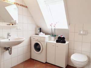 Un baño con lavadora y lavabo. en Ferienwohnung Weitblick, en Prerow