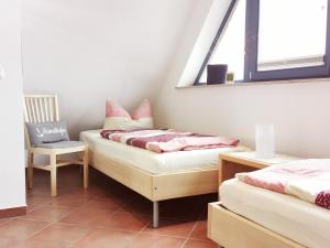 プレローにあるFerienwohnung Weitblickのベッド2台、椅子、窓が備わる客室です。