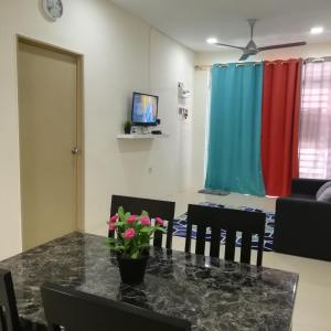 ガンバンにあるNeesa Homestay Bukit Gambang-Muslimのリビングルーム(テーブル、椅子、ソファ付)