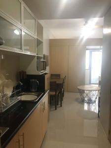 a kitchen with a sink and a table in it at Grass Residences Tower 5 in Manila