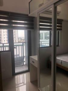 a bedroom with two windows with a view of a city at Grass Residences Tower 5 in Manila