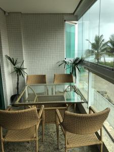 une salle à manger avec une table et des chaises en verre dans l'établissement 4 ILHAS, 2 SUITES, 2 GARAGENS, à Bombinhas